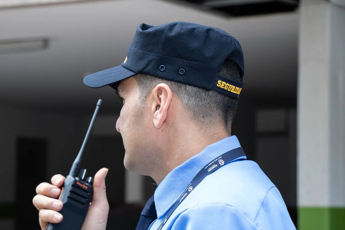 Vigilante uniformizado usando rádio comunicador Motorola no controle de acesso
